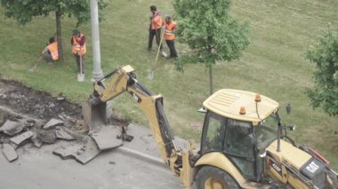 Kazıcı ve yol işçileriyle asfalt onarımı