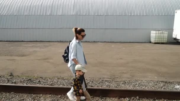 Genç anne ve oğlu raylarda yürüyorlar. — Stok video
