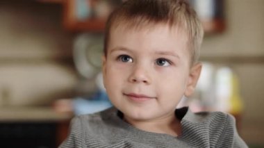 Çocuk kalemle bıyık çiziyor.