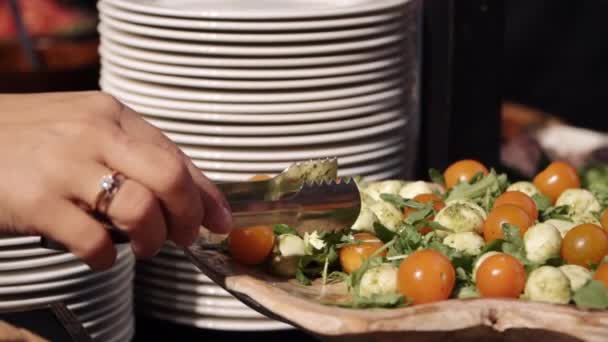 Žena sbírá občerstvení u stolu formou bufetu — Stock video