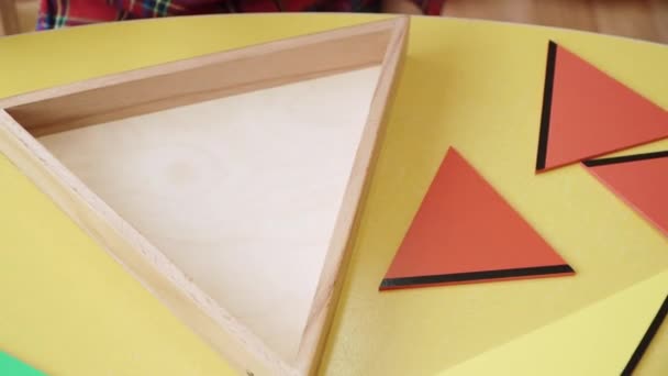 Barn med cerebral pares montera ett pussel från delar av geometriska former — Stockvideo