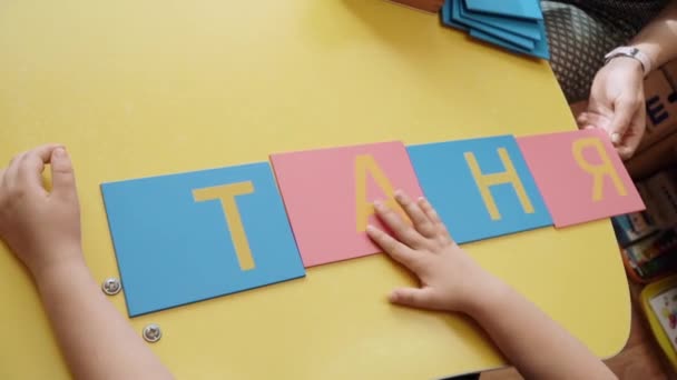 Слова, сложенные цветными буквами ребенком — стоковое видео