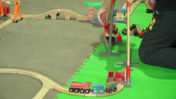 Les enfants jouent un grand chemin de fer jouet dans le pavillon intérieur — Video