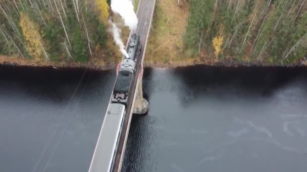 Parowóz z dymem z komina na moście nad rzeką w Karelii — Wideo stockowe