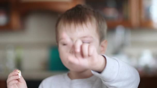 Мальчик с соплями, кашляет и ест попкорн — стоковое видео
