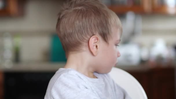 En pojke med snor är stygg och vänder sig bort — Stockvideo