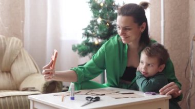 Anne ve oğul kar tanelerini kestiler.