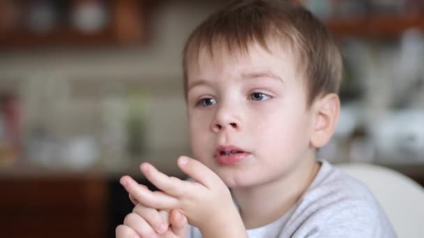 Chlapec s usmrkanec zívá a dívá se na televizi — Stock video