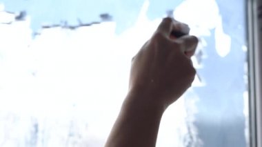 Kazıyıcılı tişörtlü bir kız güneş koruyucu filmi kaldırıyor.