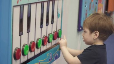 Çocuk bir müzikalin tuşlarına basıyor