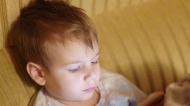 Hasta çocuk mutfakta börek yiyor.