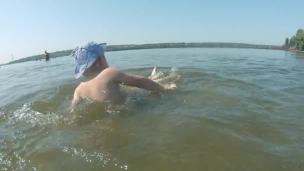 Een driejarige jongen zwemt in de rivier de Dnjepr. — Stockvideo