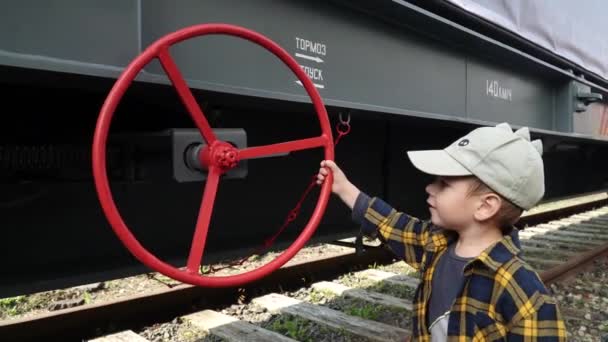 Мальчик крутит колесо тормоза — стоковое видео
