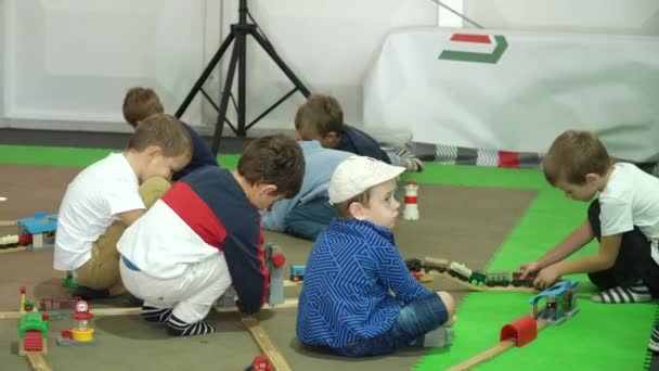 Τα παιδιά παίζουν ένα μεγάλο σιδηρόδρομο παιχνίδι στο εσωτερικό περίπτερο — Αρχείο Βίντεο