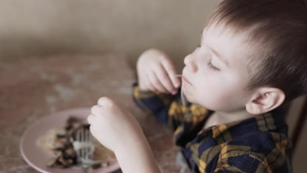 Het kind eet Chinese noedels met zijn handen — Stockvideo
