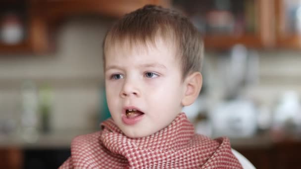 Een ziek kind likt zijn vingers in zure room — Stockvideo