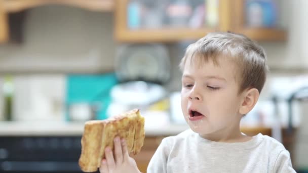 Sick child eating puff in the kitchen — Stockvideo