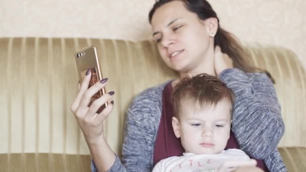 Jongen Met Moeder Bank Kijken Naar Telefoons — Stockvideo