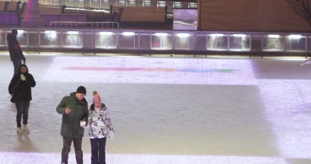 Visitantes de pista de patinaje y decoración de escenario y Navidad en el fondo — Vídeo de stock