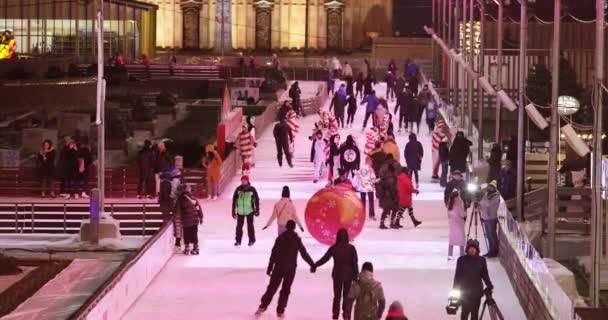 Ijsbaan bezoekers en podium en kerst decoratie op de achtergrond — Stockvideo