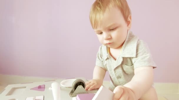 Bebé juega con cubo ocupado — Vídeo de stock