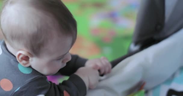 Baby jongen probeert op te staan op zijn voeten — Stockvideo