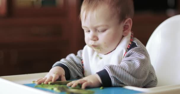 Baby jongen eten avocado — Stockvideo