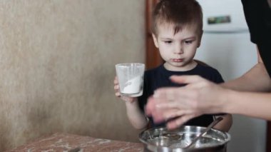 Çocuk masada cheesecake hazırlıyor.