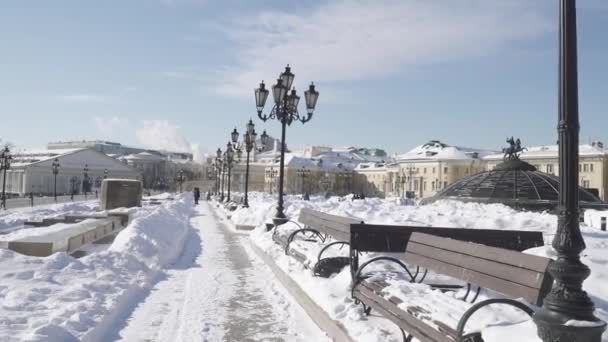 Domos cubiertos de nieve del centro comercial Okhotny Ryad y caminos peatonales despejados de nieve con vistas al Kremlin desde el lado del Alexander Garden — Vídeos de Stock