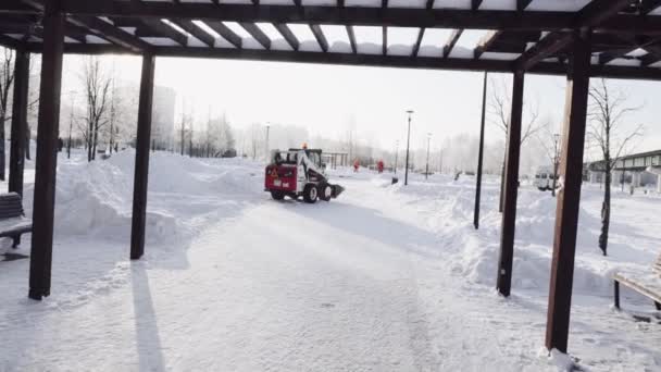 Nettoyage de la neige dans le parc municipal avec un tracteur — Video