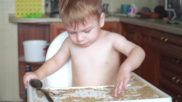 Хлопчик грає з горохом і квасолею — стокове відео