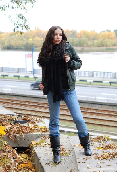 Ragazza adolescente in giacca a vento e jeans contro il fiume — Foto Stock