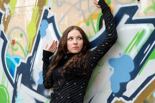 Ragazza adolescente vicino muro graffiti — Foto Stock