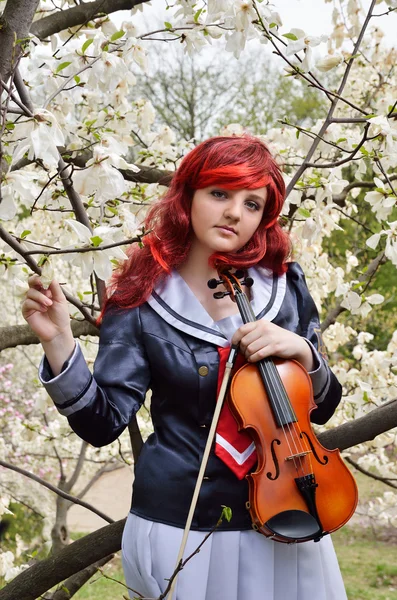Adolescente avec un violon dans le jardin fleuri — Photo
