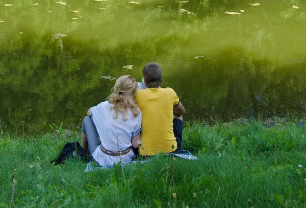 Coppia felice vicino allo stagno verde — Foto Stock