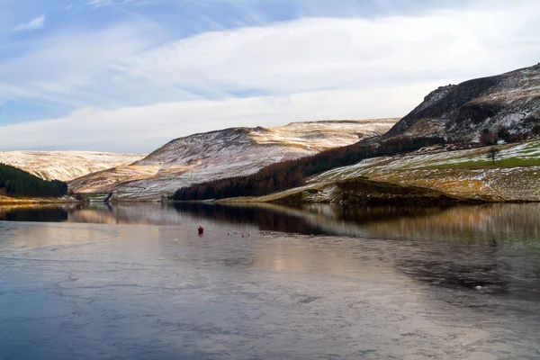 Across the ice to the hills on dove stone reservoir — Stock Photo, Image