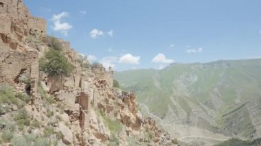 Eski ve terk edilmiş şehrin havadan görünüşü. Başla. Bir dağın yamacında inşa edilmiş eski taş binaların üzerinde uçuyorlar..