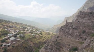 Eski ve terk edilmiş şehrin havadan görünüşü. Başla. Bir dağın yamacında inşa edilmiş eski taş binaların üzerinde uçuyorlar..