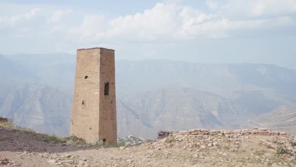 Ερειπωμένος πέτρινος πύργος σε φόντο βουνών. Πάμε. Αρχαίος εγκαταλελειμμένος πύργος στην ορεινή περιοχή κάτω από τον λαμπερό ήλιο. — Αρχείο Βίντεο