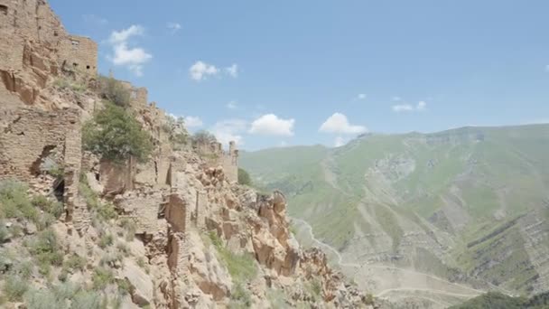 古代の放棄された都市の空中ビュー。行動だ。山の斜面に建てられた古い石造りの建物の上を飛ぶ. — ストック動画