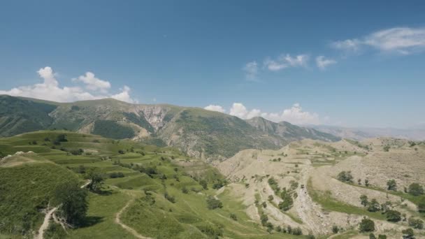 Vista aérea da paisagem incrível com belo vale em um dia ensolarado. Acção. Voando acima das montanhas de verão no fundo azul do céu nublado. — Vídeo de Stock