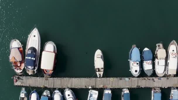 Vista superior aérea de la bahía de yates y turquesa superficie de agua tranquila con destellos de sol. Acción. Barcos y yates amarrados por el muelle. — Vídeo de stock