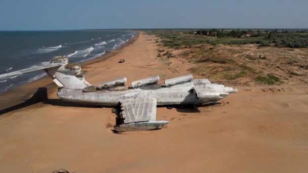 Luchtfoto van een geruïneerd verlaten vliegtuig gevonden in een onbewoond eiland in de buurt van de zee op blauwe lucht achtergrond. Actie. Concept van ramp en dood. — Stockvideo