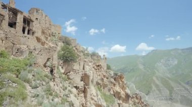 Eski ve terk edilmiş şehrin havadan görünüşü. Başla. Bir dağın yamacında inşa edilmiş eski taş binaların üzerinde uçuyorlar..