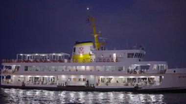 Güzel bir turist gemisi gece parlıyor. Başla. Büyük turist teknesi kıyıya yüzerken parlıyor. Akşamları Türkiye kıyıları boyunca deniz gemisiyle yolculuk