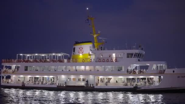 Hermosa embarcación turística brilla por la noche. Acción. Gran barco turístico brilla mientras nada hasta la orilla. Viaje en barco marítimo a lo largo de las costas de Turquía por la noche — Vídeos de Stock