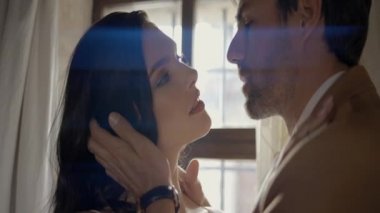 Yeni evliler pencerenin arka planına sarılır. Başla. Güzel yeni evliler, birbirlerine tutkuyla parlak pencereden bakarlar. Yeni evlilerin yakın ve tutkulu görüşleri