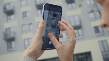 Rusya, MOSCOW - 27 Eylül 2021: Kadın telefonda binanın fotoğraflarını çekiyor. Başla. Kadın telefonu tutuyor ve binanın fotoğraflarını çekiyor. iPhone 13 'ün yeni gelişmiş kamerası
