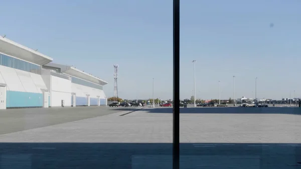 En silhuett av en affärsman som använder smartphone, har telefonsamtal och går framför panoramafönster. HDR. Seriös man med en smartphone inomhus vid fönstret på blå himmel bakgrund. — Stockfoto