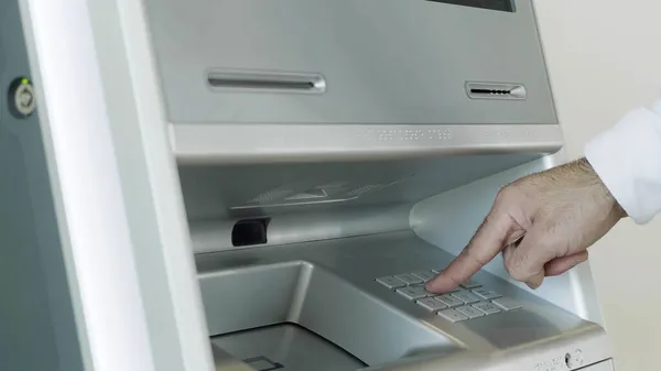 Mão masculina anexando cartão para a máquina bancária ATM para a realização de transações financeiras. HDR. Fechar-se do homem que entra no código do pino do cartão bancário. — Fotografia de Stock